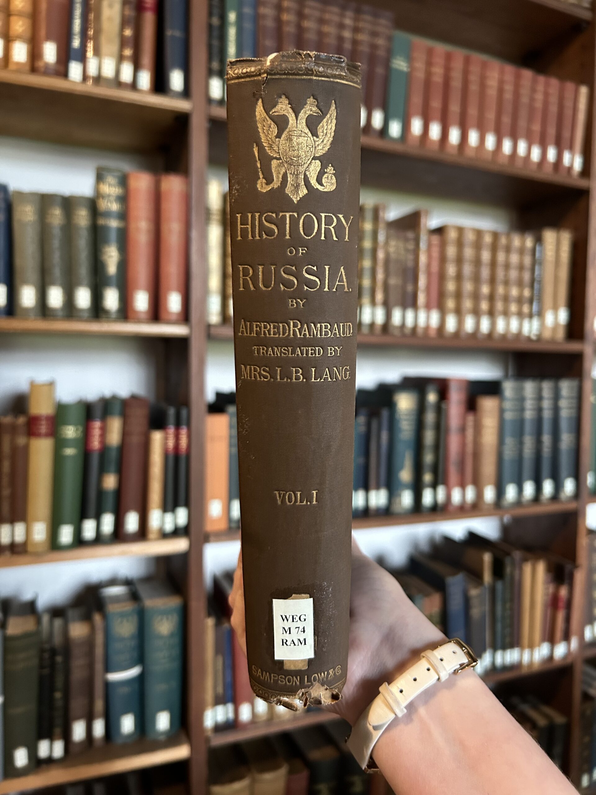 A copy of History of Russia as mentioned in the body text. It is held up in front of a set of bookshelves. The book itself has a blue spine and the title is picked out in gold