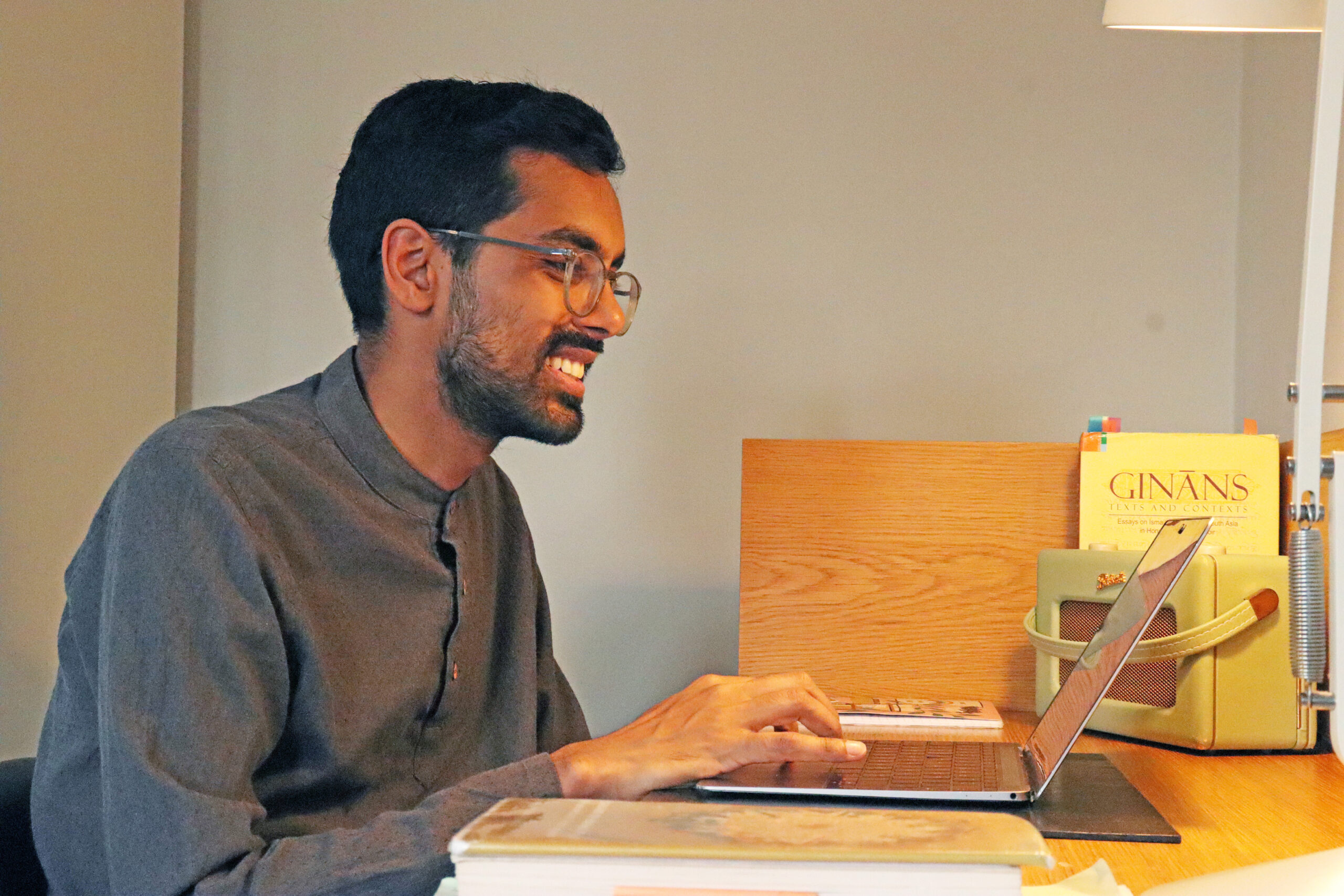 A landscape photograph of Imran Visram working on his laptop at a desk